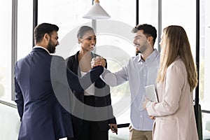 Cheerful young diverse business colleagues shaking hands