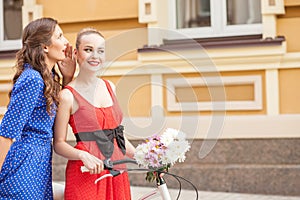 Cheerful young female friends are walking in town