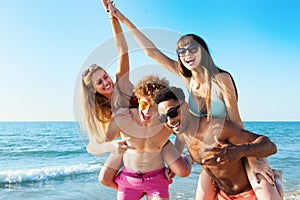 Cheerful young friends enjoying summertime on the beach