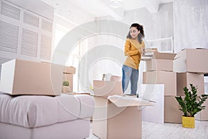 Cheerful young girl packing before moving out of dorm