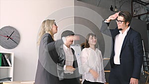 Cheerful young group of people discuss something in the office and giving high five