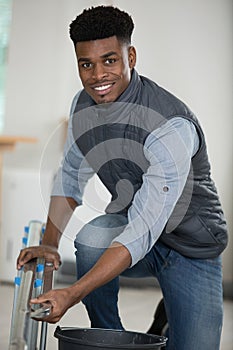cheerful young handyman holding ladder
