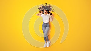 Cheerful Young Lady With Headphones Listening To Music, Yellow Background