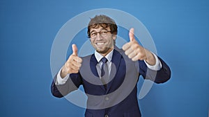 Cheerful young man in business suit celebrates success with a winning thumbs-up gesture, smiling, radiating positivity. captured