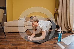 Cheerful young man doing plank on