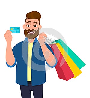 Cheerful young man holding shopping bags. Male character showing a credit, debit, ATM, bank card in hand. Modern lifestyle,