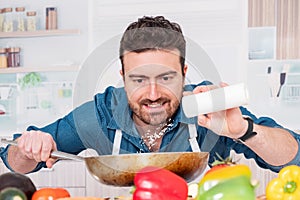 Cheerful young man preparing food at home