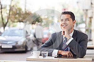 Cheerful young man is resting in cafeteria