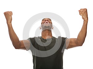 Cheerful young man shouting with arms raised in success