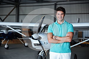 Cheerful young man standing near small plane