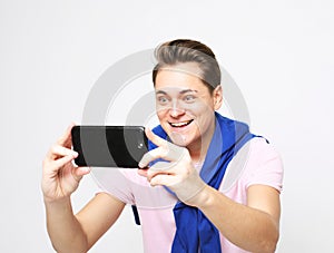 Cheerful young man taking a selfie isolated over white background