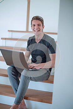 Cheerful young man talking by video link using laptop