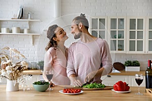 Cheerful young married couple enjoying romantic time in kitchen