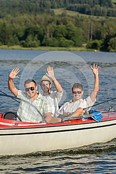 Cheerful young men sitting in motorboat