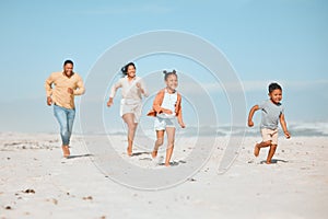 Cheerful young mixed race family running on the beach, Happy mother and father with two children having fun during