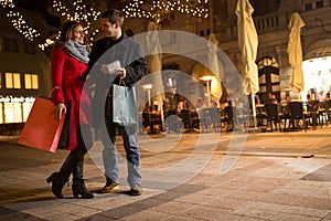 Cheerful young people doing Christmas shopping