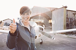 Cheerful young pilot giving a thumbs up