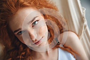 Cheerful young redhead lady lies on hammock