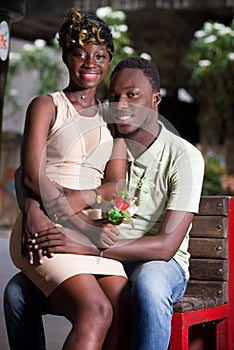 Cheerful young romantic couple sitting outdoors