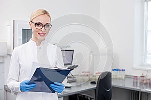 Cheerful young scientist is working in lab