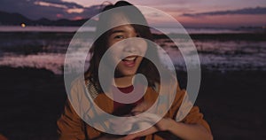 Cheerful young traveler Asian lady with backpack feeling fun dancing smile to camera in camping on beach at night. Girl enjoy