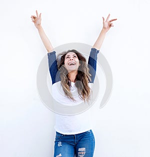 Cheerful young woman with arms raised and looking up