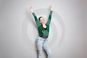 Cheerful young woman with arms raised up