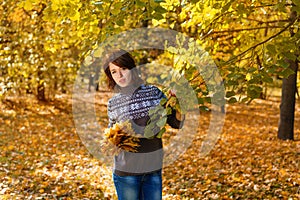 Cheerful young woman in autumn Park smiling on a Sunny day