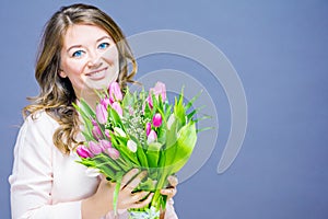 Cheerful young woman with bunny ears and Easter egg basket and tulips Flowers Looking at camera