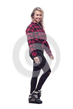 cheerful young woman in a checked shirt looking at you.