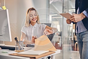 Cheerful young woman checking documents at work