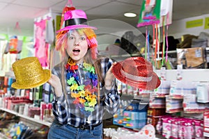 Cheerful young woman choosing funny headdresses