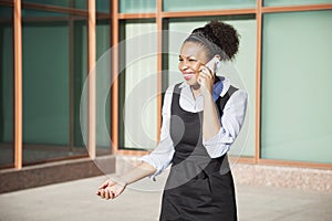 Cheerful young woman in formals using mobile phone