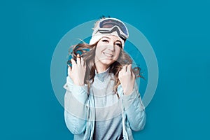 Cheerful young woman in a hat and ski mask. A girl in a winter jacket