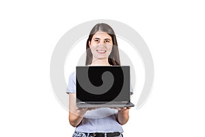 Cheerful young woman holding a laptop in her hands showing the blank screen to camera isolated on white background. PC