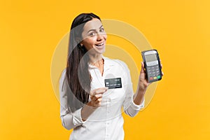 Cheerful young woman holding wireless modern bank payment terminal to process and acquire credit card payments isolated