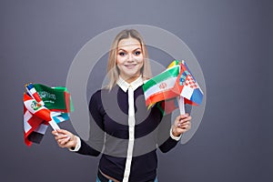 Cheerful young woman with a large set of flags of different countries of the world