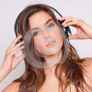 Cheerful young woman listening music with headphon