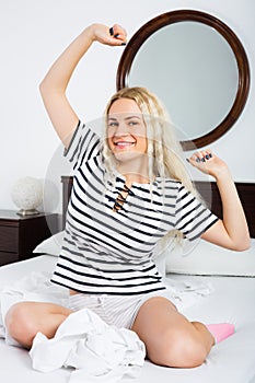 Cheerful young woman with long hair awaking photo