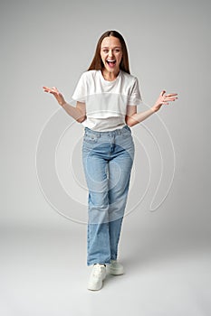 Cheerful young woman looking at camera smiling laughing over gray background