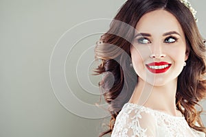 Cheerful young woman with red lips makeup and curly hair smiling