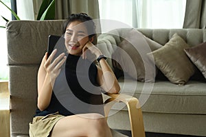 Cheerful woman resting inlaying room and having video call on her smart phone. photo