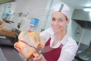 cheerful young woman selling fresh chicken