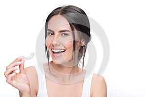 Cheerful young woman showing clear aligner photo