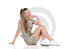 Cheerful Young Woman Sitting On A Floor