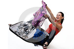 Happy travel woman unpacking her suitcase photo