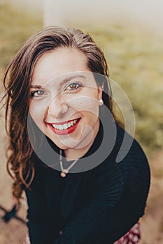 Cheerful young woman smiling looking straight ahead