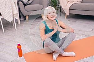 Cheerful young woman smiling while practicing yoga