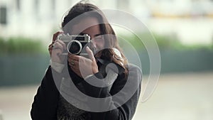 Cheerful young woman using photo camera