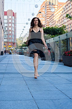 Cheerful young woman walks barefoot